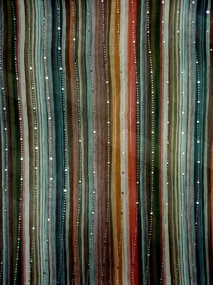 Close-up of striped, sequinned textile in teal, rust and cream